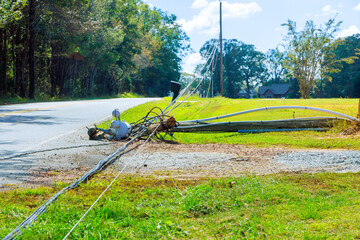 Tornado damage caused by hurricanes leads to damaged power lines lying on ground with broken wires.
