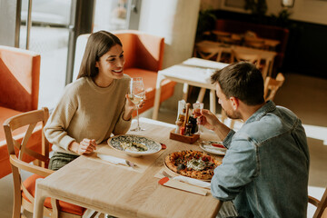 A cozy dinner date between two people enjoying drinks in a stylish restaurant atmosphere