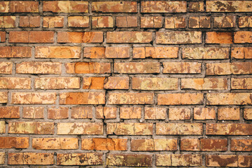 Old grungy brick wall. Free space for an inscription. Can be used as a background or poster. Fragment of a wall with bumps and shabby plaster.