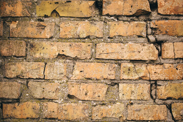 Fototapeta premium Non-linear pattern of an old shabby brick wall with natural patterns of paint chips. Restoration of semi-antique brick walls. A basic neutral background for a design project.
