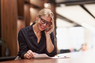 A Professional Woman Engaged in a Phone Conversation While at Work in the Office Environment