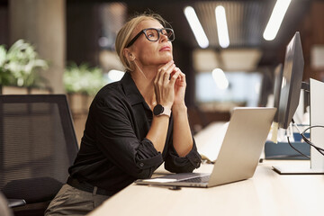 A Thoughtful Professional at Work Within a Modern Office Environment Setting, Engaged in Tasks