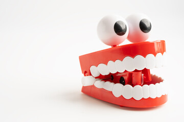 Tooth funny toy denture red color jaw and eye on white background with copy space.