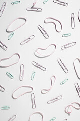 Paper clips and rubber bands stationery on a white background. Top view, flat lay
