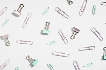Stationery, paper clips, binders on a white background. Top view, flat lay