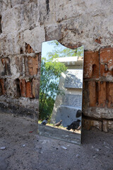 Reflection of Pigeons in a Broken Mirror Against an Old Brick Wall Outdoors