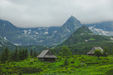 Traditional Wooden Huts in the Tatra Mountains with a Cloud-Covered Peak
