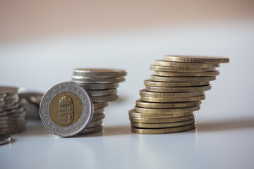 Stacked Hungarian Forint Coins in 2 towers that are leaning indicating eventual collapse