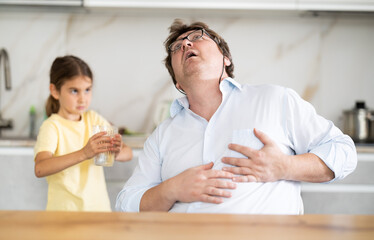 Fototapeta premium My father heart ached. Little daughter gives her father glass of water