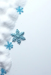 Mehrere blaue Schneeflocken liegen entlang einer Schneeschicht am linken Rand eines wei&szlig;en Hintergrunds und bieten viel Platz f&uuml;r winterliche Texte. Generative KI