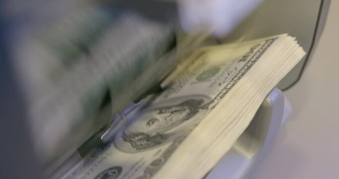 100 dollar bills counted in money counting machine. Cash money dollars into banknote counter. High quality video 6k 4:2:2 10bit downscale 4k 