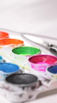 Vertical Video Little Girl Dipping Brush Picking Up Pink Paint From A Palette