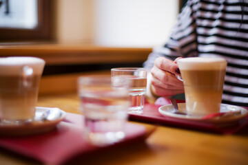 Two Lattes on Table with Woman Hand