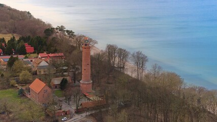 A drone captures Gąski beach, West Pomeranian Voivodeship, Poland, featuring a red brick lighthouse, Baltic Sea. © Grzegorz