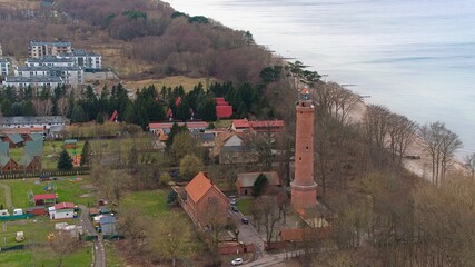 A drone captures Gąski beach, West Pomeranian Voivodeship, Poland, featuring a red brick lighthouse, Baltic Sea. © Grzegorz