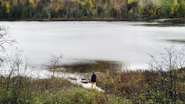 Man Preparing Canoe by the Lakeshore in Autumn in Mandeville, Quebec, Canada