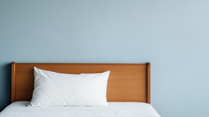 Cozy bed with white pillows against a light blue wall, warm and inviting ambiance.