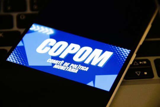 COPOM - O Comit&ecirc; de Pol&iacute;tica Monet&aacute;ria &eacute; um &oacute;rg&atilde;o do Banco Central do Brasil (Bacen) que define a taxa b&aacute;sica de juros da economia brasileira, a Selic, a cada 45 dias. 
