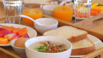 Nutritious breakfast with porridge, bread, fruit, orange juice on wooden table. Healthy Eating and Lifestyle