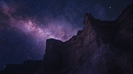 The edge of a cliff under the galaxy's glow, with stars casting soft light on the rugged rock formations