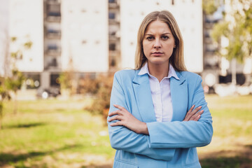 Portrait of angry businesswoman with arms crossed standing outdoor.	