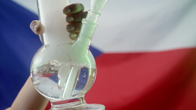 Woman smoking medical marijuana, glass water bong on Czech flag background. Cannabis tobacco, Shisha in Czechia