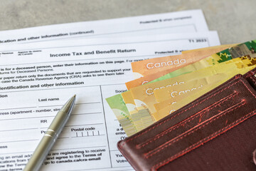 Income tax return in Canada. Financial concept. Tax form, Canadian dollars and tax calculation on calculator. close up