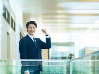 ビジネス、ビジネスパーソン、ガッツポーズ、元気、営業、建設、デベロッパー、オフィス、企業、ゼネコン、ビル、ロビー、人材、転職、就職、挑戦、チャレンジ、成長、仕事、職場、がんばる、努力、パワー、応援、コピースペース、広告、信頼、自信、若い、ビルメン、やる気、モチベーション、男性、日本人、笑顔、ビジネスマン、会社員、スーツ、サラリーマン、会社、オフィスビル、30代、管理職、成功、目標、サクセス、カメラ