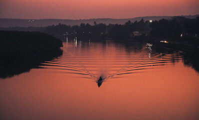 Silhouette of a boat crossing a river
