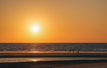 Ocean shore at low tide at sunset