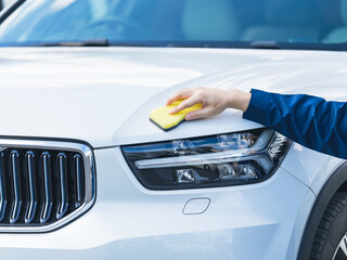 洗車、洗車場、男性、作業員、日本人、カーワックス、カーコーティング、メンテナンス、コーティング、自動車、ワックス、スポンジ、洗う、手洗い、ムース、クルマ、ガレージ、駐車場、ガソリンスタンド、フロント、ドライバー、運転、ピカピカ、つや、ホワイト、白、美しい、ボディ、車、仕事、スタッフ、洗浄、働く、修理、整備、手作業、愛車、ドライブ、マイカー、塗装、ケア、汚れ、傷、防止、予防、対策、水アカ、ヘッドライ © metamorworks