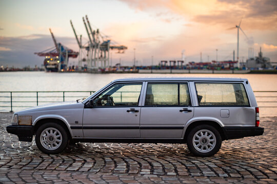 Hamburg, Germany, April 13, 2023: Silver Volvo 940 station wagon with bump and repair sheet, side view, harbor background, horizontal format