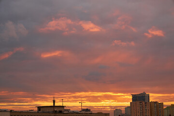 Fototapeta premium Silhouettes of Buildings Against a Fiery Sunset