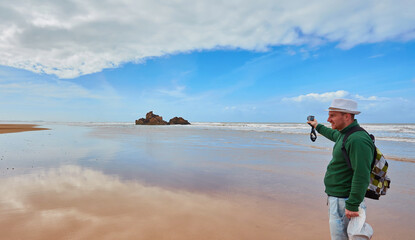 A young tourist walks along the ocena coast enjoying the views, Morocco
