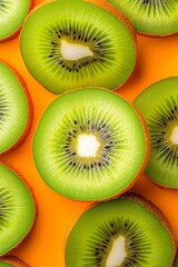 Fototapeta premium Kiwi slices arranged on a vibrant orange background