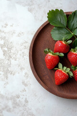 Strawberry. Fresh juicy strawberries with leaves on wooden plate. Suitable for marketing or business purposes. Banner with place for text.