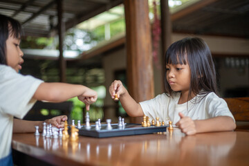 Fototapeta premium Two young girls playing a game of chess
