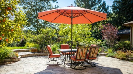 Obraz premium A large, colorful patio umbrella provides shade for a stylish outdoor dining set in a sunlit backyard.