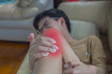 Closeup young boy feeling pain in his knee after play at home. Healthcare and medical concept.