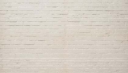 Fototapeta premium A white brick wall with varying brick sizes and a slight variation in color is captured in a low-angle shot, showcasing its texture and depth