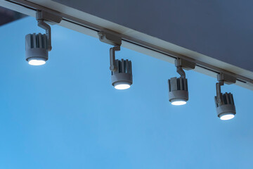 Directional LED lights on rails under the ceiling in a modern warehouse, shopping center building,...