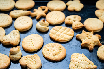 Homemade cookies of cheerful shapes made by a child on the protvina. A family hobby.