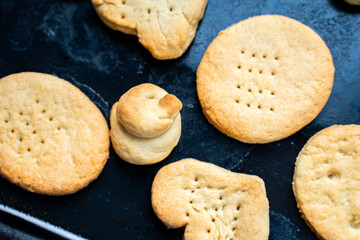 Homemade cookies of cheerful shapes made by a child on the protvina. A family hobby.