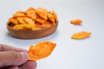 A person is holding a piece of snakefruit in their hand
