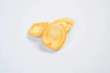 Three small, round, yellow pastries sit on a white background