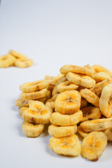 A pile of banana chips on a white background