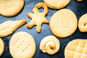 Homemade cookies of cheerful shapes made by a child on the protvina. A family hobby.