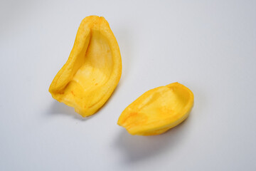Two pieces of yellow fruit, one of which is cut in half