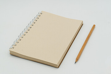  blank spiral notebook and pencil placed on a clean white background. This simple yet versatile composition is ideal for themes of creativity, organization, planning, or writing. Perfect for education