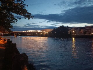 Pont sombre reflété dans le canal en soirée